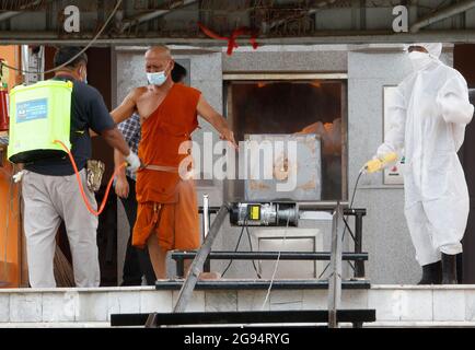 Nonthaburi, Thailand. Juli 2021. Ein Mann sprüht Desinfektionsmittel an einen buddhistischen Mönch in einem Krematorium während einer Trauerfeier im Wat Bang Muang, in der Provinz Nonthaburi, am Stadtrand von Bangkok. Thailand hat bisher 481,967 Coronavirus-Fälle mit 327,789 Genesten und 3,930 Todesfällen bestätigt. (Foto von Chaiwat Subprasom/SOPA Images/Sipa USA) Quelle: SIPA USA/Alamy Live News Stockfoto