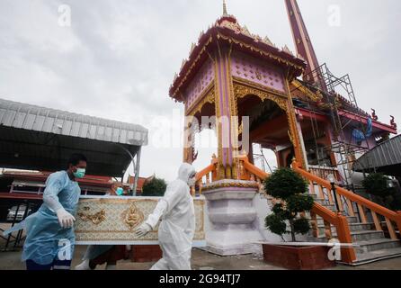 Nonthaburi, Thailand. Juli 2021. (ANMERKUNG DER REDAKTION: Bild zeigt den Tod) Tempelarbeiter tragen persönliche Schutzanzüge (PSA) und tragen während einer Trauerfeier im Wat Bang Muang in der Provinz Nonthaburi, am Stadtrand von Bangkok, einen Sarg eines COVID-19-Opfers zu einem Krematorium. Thailand hat bisher 481,967 Coronavirus-Fälle mit 327,789 Genesten und 3,930 Todesfällen bestätigt. (Foto von Chaiwat Subprasom/SOPA Images/Sipa USA) Quelle: SIPA USA/Alamy Live News Stockfoto