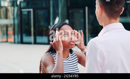 Nahaufnahme des Mixed-Race-Mädchens, das mit ihrem Freund draußen streitig ist und ihn dann allein lässt. Paar streitet zu einem Zeitpunkt. Stockfoto