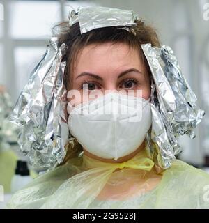 Frau färbt ihre Haare in einem Friseurladen, den Prozess des Färbens ihr Haar mit Folie. Neu Stockfoto