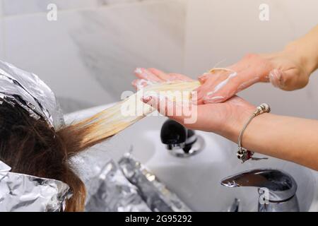 Waschen Haarfärbemittel von einem Friseur, Entfernen von Folie aus dem Haar. Neu Stockfoto