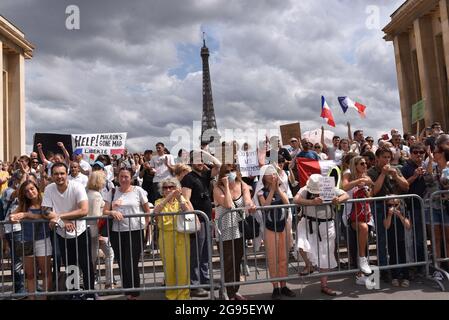 Demonstranten halten am 24. Juli 2021 auf der Esplanade „Droits de l'homme“ (Menschenrechte) auf dem Trocadero-Platz in Paris, Frankreich, Flaggen und Plakate, während eines Protestes gegen die obligatorische Impfung bestimmter Arbeitnehmer und die obligatorische Verwendung des von der französischen Regierung eingeräumten Gesundheitspasses. Seit Juli 21 müssen Menschen, die in die meisten öffentlichen Bereiche Frankreichs gehen wollen, einen Nachweis für die Covid-19-Impfung oder einen negativen Test vorlegen, da das Land sich in Fällen der hochübertragbaren Covid-19-Delta-Variante auf eine gefürchtete Spitze einstellt. Stockfoto