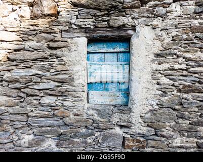 Blaues Fenster in eine Mauer aus Stein Stockfoto