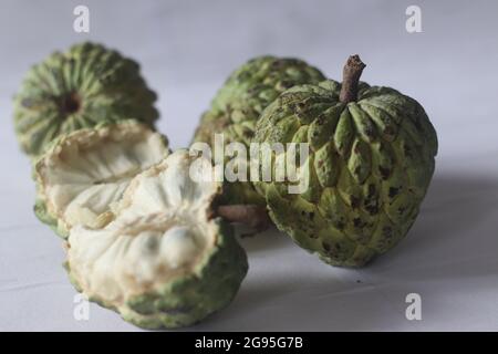 Cherimoya ist eine grüne, kegelförmige Frucht mit ledriger Haut und cremigem, süßem Fruchtfleisch. Es ist auch als Puddingapfel bekannt. Die Früchte variieren in Form, Herz Stockfoto