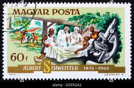 UNGARN - UM 1975: Eine in Ungarn gedruckte Briefmarke zeigt Dr. Albert Schweitzer, Patient und Mikroskop, Medizinischer Missionar und Musiker, um 1975 Stockfoto