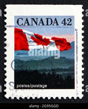 KANADA - UM 1991: Eine in Kanada gedruckte Marke zeigt die kanadische Flagge und die Berge, um 1991 Stockfoto