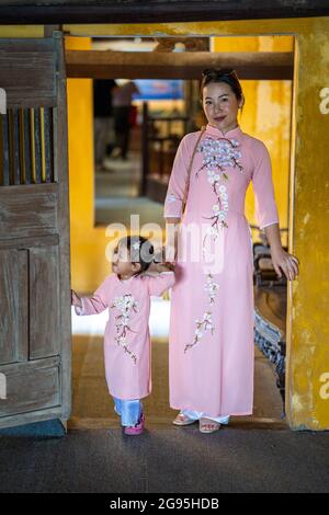 Junge asiatische Mutter in ähnlichen Kleidern mit ihrer Tochter Zeit mit ihr während eines Urlaubs gekleidet Stockfoto