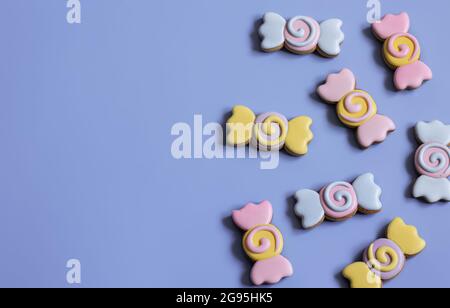 Bunte festliche Lebkuchen in Form von Bonbons mit Glasur auf einem blauen Hintergrund copy Raum bedeckt. Stockfoto