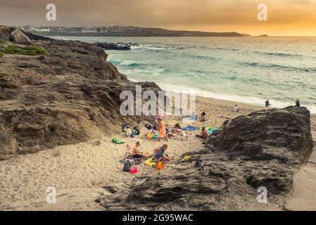 Urlauber genießen die späte Abendsonne am abgelegenen Strand von Little Fistral in Newquay in Cornwall. Stockfoto