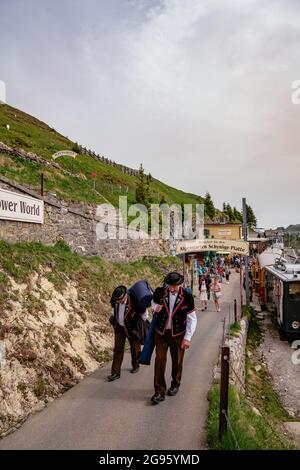 Schynige Platte, Berner Oberland, Schweiz - Touristischer Zahnradwagen vintage roter Zug und traditionelle Musiker mit Alpenhorn Stockfoto