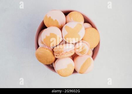 Rosa und goldene Macarons in einer Schüssel Stockfoto