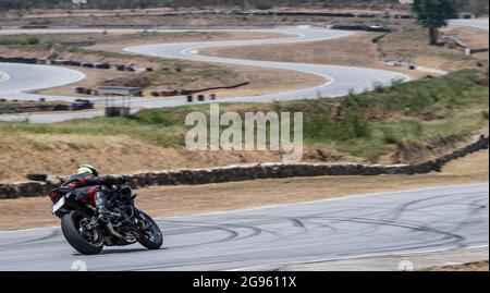 Mann trainiert mit seinem Motorrad auf der Rennstrecke Runden Stockfoto