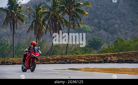 Mann trainiert mit seinem Motorrad auf der Rennstrecke Runden Stockfoto