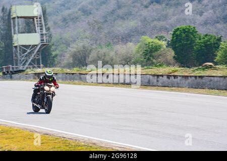 Mann trainiert mit seinem Motorrad auf der Rennstrecke Runden Stockfoto