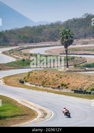 Mann trainiert mit seinem Motorrad auf der Rennstrecke Runden Stockfoto