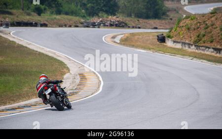 Mann trainiert mit seinem Motorrad auf der Rennstrecke Runden Stockfoto