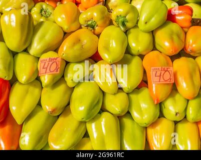 Frische gelb-grün-rote Paprika wurden auf dem Sennoy-Markt, dem billigsten in St. Petersburg, Russland, zu einem Preis von 40 Rubel pro Kilo oder 5 US-Dollar verkauft Stockfoto