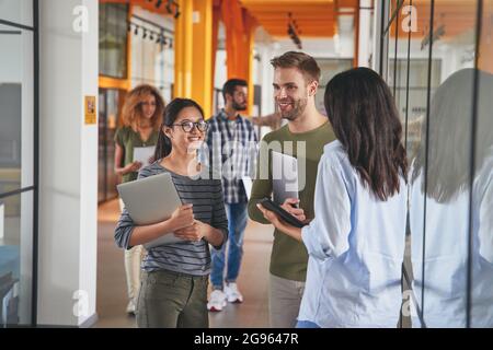 Begeisterte junge Menschen, die für ein modernes Unternehmen arbeiten Stockfoto
