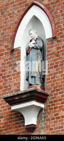 Statue von St. Vincent de Paul in der Wand eines alten Krankenhauses Stockfoto