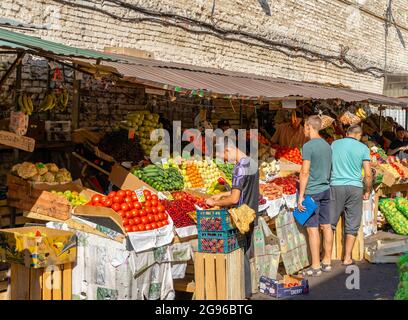 Kunden, die Obst und Gemüse von Anbietern auf dem Sennoy Outdoor-Markt kaufen, dem billigsten in St. Petersburg, Russland Stockfoto