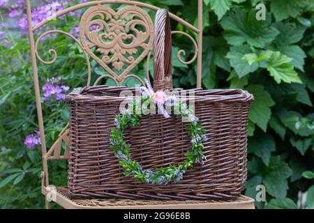 Dekoration mit Kranz aus Lavendelblüten und Kastenbaum und Weidenkorb Stockfoto