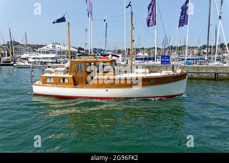 Dieser schöne hölzerne Motorcruiser Cerveza aus dem Jahr 1935 führt aus der Medina heraus in den Solent at Cowes auf der Isle of Wight Stockfoto