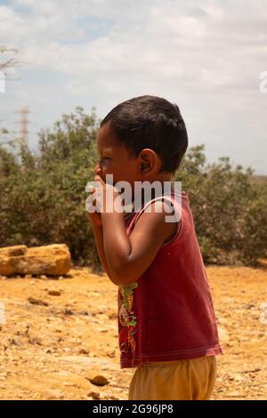 Uribia, La Guajira, Kolumbien - 28 2021. Mai: Wayuu Boy läuft an einem sonnigen Tag in der Wüste Stockfoto