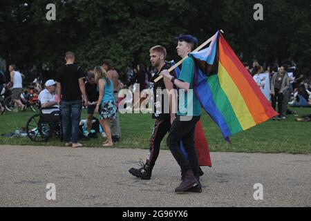 London, Großbritannien. Juli 2021. Zwei Männer, die während des Picknicks im Hyde Park die Pride-Flaggen halten, versammelten sich nach dem Reclaim Pride March zu einem Picknick im Hyde Park. Der Reclaim Pride March wurde von der LGBTQ-Gemeinschaft in London organisiert, um für die Rechte vor allem innerhalb der Transgender-Gemeinschaft zu kämpfen. Demonstranten marschierten von Westminster zum Hyde Park, der die historische Route war, als der erste Pride March 1972 in London stattfand. Kredit: SOPA Images Limited/Alamy Live Nachrichten Stockfoto