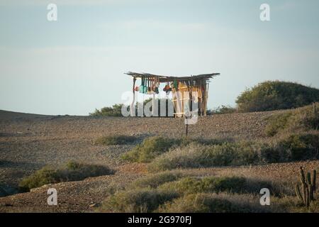 Uribia, La Guajira, Kolumbien - Mai 28 2021: Wayuu-Frau, die handgefertigte Handarbeiten in ihrem kleinen Laden verkauft Stockfoto