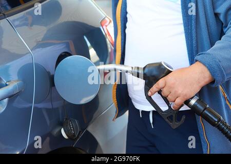Nahaufnahme eines handbetanken eines Autos an einer Tankstelle von mans Stockfoto