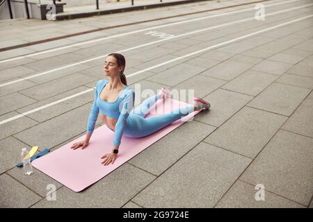 Schlanke junge kaukasische Dame macht Sport im Freien in der Stadt Stockfoto