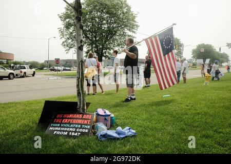 Ein Mann trägt eine amerikanische Flagge von „Betsy Ross“ zusammen mit anderen Demonstranten vor dem Krankenhaus St. Joseph Mercy Oakland, Während der Demonstration versammelten sich Gesundheitshelfer und andere in mehreren Krankenhäusern in Michigan, um gegen die jüngste Ankündigung von Trinity Health und Henry Ford Health Systems zu protestieren, wonach Krankenschwestern und andere Gesundheitshelfer unter ihrer Beschäftigung den Coronavirus-Impfstoff erhalten müssen. Die Ankündigung wurde von einigen sowohl in der Gemeinschaft als auch von der WHO als Krankenschwestern in diesen Gesundheitssystemen feindselig aufgenommen. Stockfoto