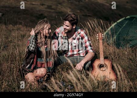 Junge liebende paar Touristen in der Natur. Hübscher Mann und schöne Frau umarmen sich in der Nähe des Zeltes im Camping. Glückliches Paar in der Liebe Stockfoto