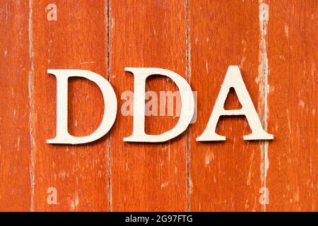 Buchstabenbuchstabe in Wort DDA (Abkürzung für Abschreibung, Erschöpfung und Abschreibung oder Nachfragekonto) auf altem roten Holzplatte-Backgroun Stockfoto