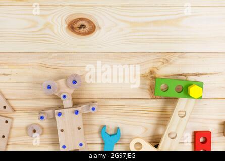 Ein farbenfroher Holzbausatz für Kinder auf Holz. Set von Werkzeugen auf Holztisch. Spiele und Werkzeuge für Kinder in der Vorschule oder Kindertagesstätte. Stockfoto