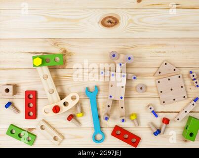 Ein farbenfroher Holzbausatz für Kinder auf Holz. Set von Werkzeugen auf Holztisch. Spiele und Werkzeuge für Kinder in der Vorschule oder Kindertagesstätte. Stockfoto