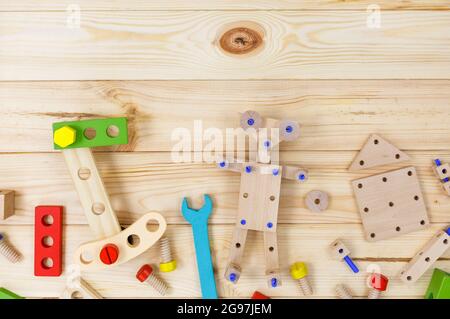 Ein farbenfroher Holzbausatz für Kinder auf Holz. Set von Werkzeugen auf Holztisch. Spiele und Werkzeuge für Kinder in der Vorschule oder Kindertagesstätte. Stockfoto