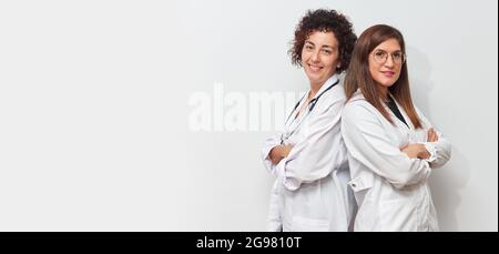 Porträt von zwei Ärztinnen, die von hinten auf die Kamera schauen Stockfoto