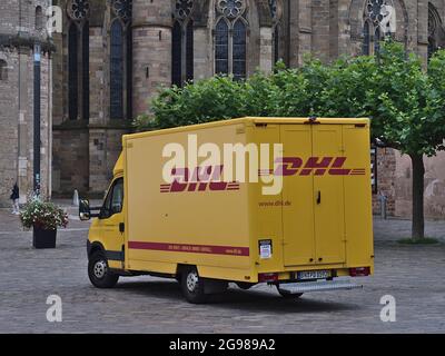 Gelber Lieferwagen des Transportunternehmens DHL (Teil der Deutsche Post DHL Group) mit rotem Firmenlogo auf dem Domfreihof im Zentrum von Trier. Stockfoto