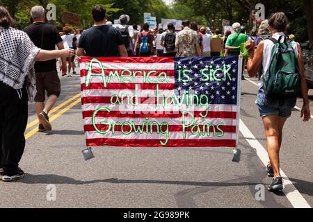 Washington, DC, USA, 24. Juli 2021. Im Bild: Zwei Demonstranten tragen während des DC-Marsches für Medicare for All eine amerikanische Flagge mit Botschaften auf beiden Seiten. Der marsch ist Teil einer landesweiten Nachfrage nach universeller Gesundheitsversorgung mit Veranstaltungen in 56 Städten. Kredit: Allison Bailey / Alamy Live Nachrichten Stockfoto