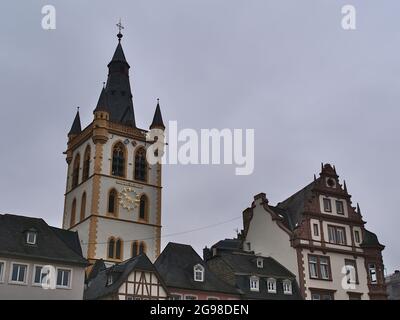 Historische Altbauten am Hauptmarkt in der Stadt Trier, Rheinland-Pfalz, Deutschland mit Kirchturm der katholischen Kirche St. Gangolf am bewölkten Tag. Stockfoto