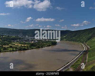 Schöne Panoramasicht auf Rheintal mit Fluss auf hohem Wasserstand mit Straße, Schienen und grünen Hügeln und Stadt Boppard, Deutschland. Stockfoto