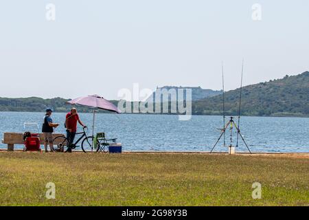 orbetello, italien juli 24 2021:Fischer am Ufer des Meeres in Orbetello Stockfoto