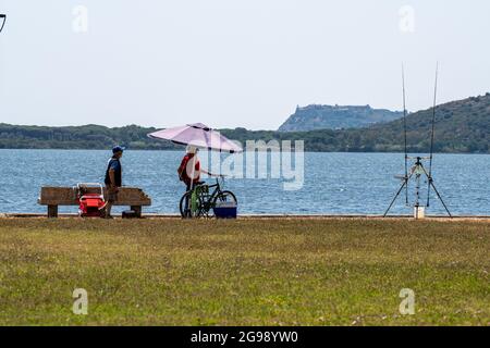 orbetello, italien juli 24 2021:Fischer am Ufer des Meeres in Orbetello Stockfoto