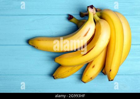 Köstliche reife Bananen auf einem blauen Holztisch Stockfoto