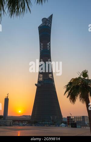 Doha, Katar – 1. Oktober 2019: Der Torch Tower im Doha Sport City Complex bei Sonnenuntergang neben der Aspire Masjid Moschee vor klarem Himmel Stockfoto