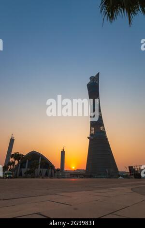 Doha, Katar – 1. Oktober 2019: Der Torch Tower im Doha Sport City Complex bei Sonnenuntergang neben der Aspire Masjid Moschee vor klarem Himmel Stockfoto