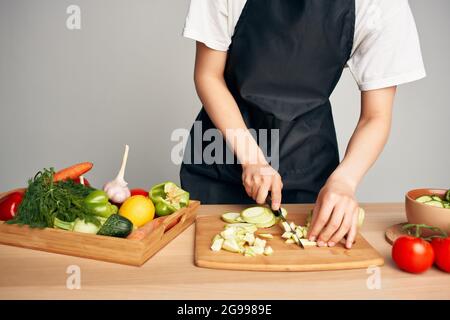 Hausfrau in der Küche schneiden Gemüse auf einem Schneidebrett Vitamine Stockfoto