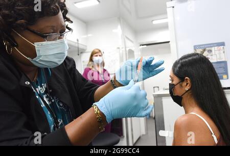 Krankenschwester Carlene Fleming bereitet sich darauf vor, einem Patienten auf einer mobilen Impfveranstaltung auf dem Campus der University of Central Florida und des Valencia College eine Dosis COVID-19-Impfstoff zu verabreichen. Florida führt die Nation bei neuen Coronavirus-Fällen an, da die Krankenhausaufenthalte ansteigen. Stockfoto
