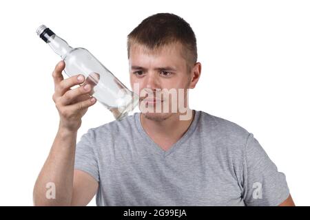 Junger Mann mit Borsten, der eine leere Glasflasche hält Stockfoto